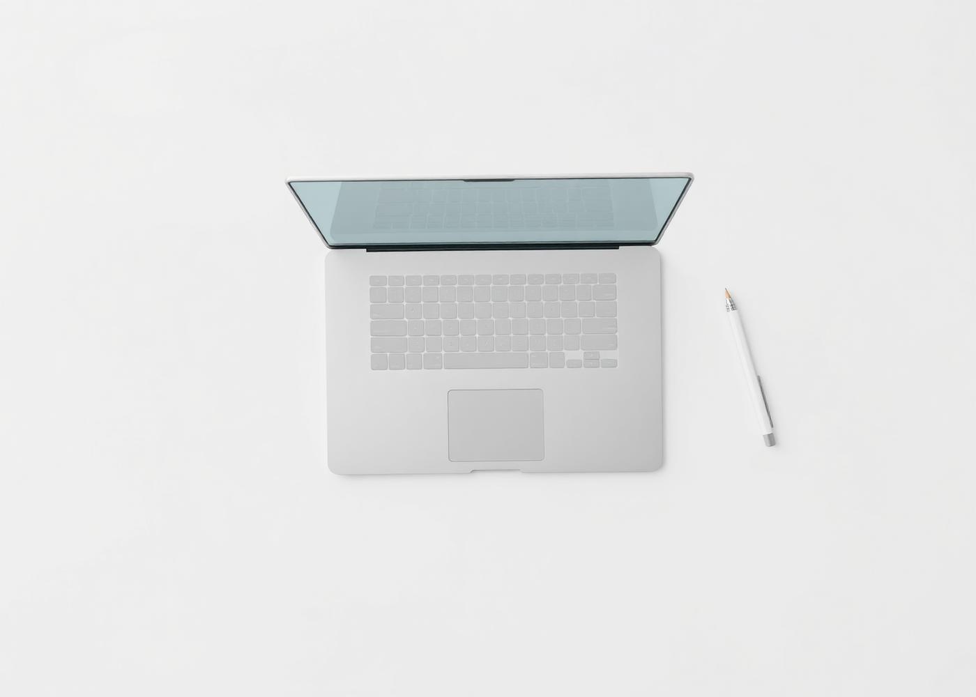 Overhead photograph of a laptop and pencil on a white desk